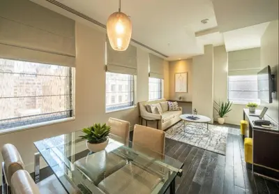 a living room with a glass table and a couch at Charming 2BR Apartment Near Times Square in New York