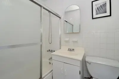 a white bathroom with a sink and a shower at Midtown West Furnished 3 Bedroom Apartment in New York