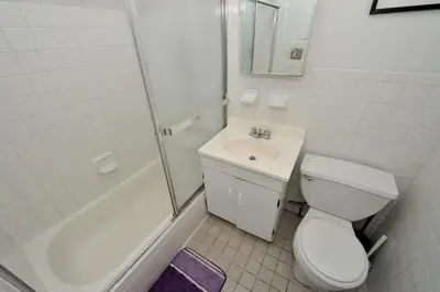 a bathroom with a toilet and a sink and a shower at Midtown West Furnished 3 Bedroom Apartment in New York