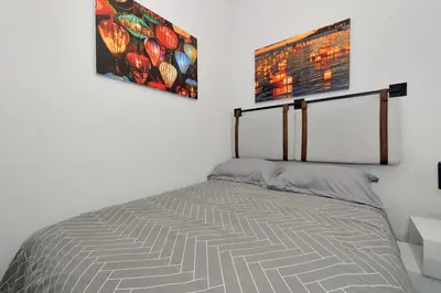 a bed in a bedroom with two pictures on the wall at Midtown West Furnished 3 Bedroom Apartment in New York