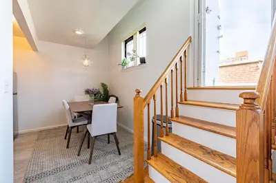 a dining room with a table and chairs and a staircase at Amazing Furnished 1 BR Penthouse Midtown West in New York
