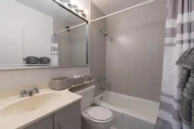 a bathroom with a sink and a toilet and a tub at Amazing Furnished 1 BR Penthouse Midtown West in New York