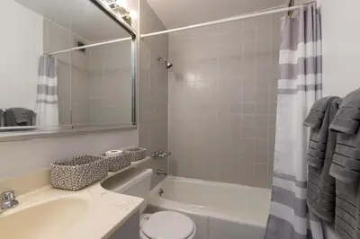 a bathroom with a tub and a sink and a toilet at Amazing Furnished 1 BR Penthouse Midtown West in New York