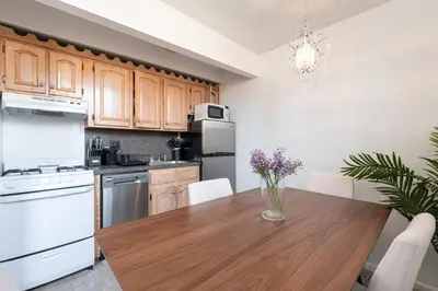 a kitchen with a wooden table and white appliances at Amazing Furnished 1 BR Penthouse Midtown West in New York