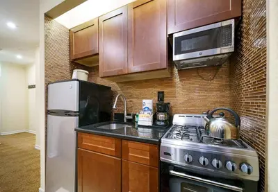 a kitchen with a stove and a microwave at 3BR Apartment in Big Apple in New York