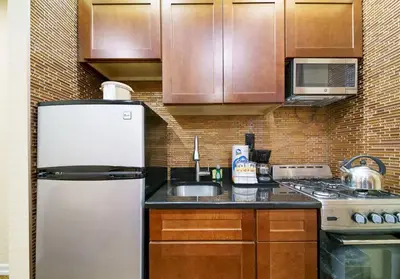 a kitchen with a refrigerator and a sink at 3BR Apartment in Big Apple in New York