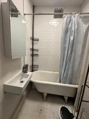 a white bathroom with a tub and a sink at Cozy 2BR in NYC Lenox Hill in New York