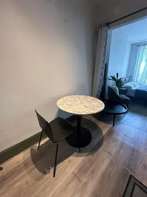 a table and chairs in a living room with a couch at Cozy 2BR in NYC Lenox Hill in New York