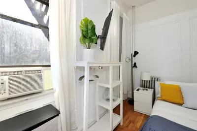 a white room with a bed and a window at Midtown West Furnished Apartment 3BR in New York