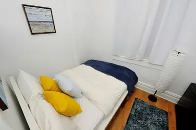 a white couch with yellow pillows in a room at Midtown West Furnished Apartment 3BR in New York