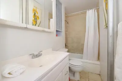a white bathroom with a sink and a toilet at Midtown West Furnished Apartment 3BR in New York