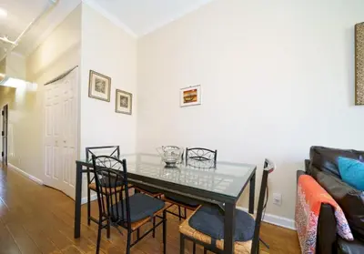 a dining room with a glass table and chairs at Midtown West Furnished Apartment 3BR in New York