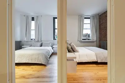 a bedroom with two beds and two windows at XL Prime Tribeca Furnished Loft in New York