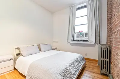 a bedroom with a bed and a brick wall at XL Prime Tribeca Furnished Loft in New York