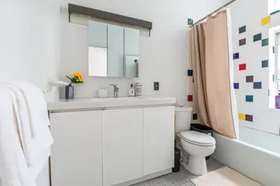 a white bathroom with a sink and a toilet at XL Prime Tribeca Furnished Loft in New York