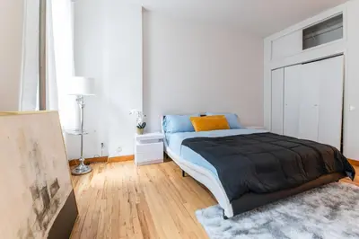 a bedroom with a bed in a white room at XL Prime Tribeca Furnished Loft in New York
