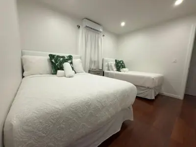 a white bedroom with two beds and a window at Modern Retreat Poconos 3BR Fire Pit Skiing in East Stroudsburg