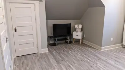 a room with a door and a television and a table at The Grand Parkway is a unique getaway with charm! in East Orange