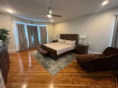 a bedroom with a bed and a couch at The Grand Parkway is a unique getaway with charm! in East Orange