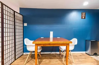 a dining room with a wooden table and white chairs at The Hygge Way, 20MIN TO NYC Times Sq in North Bergen