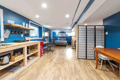 a kitchen with blue walls and a dining room with a table at The Hygge Way, 20MIN TO NYC Times Sq in North Bergen