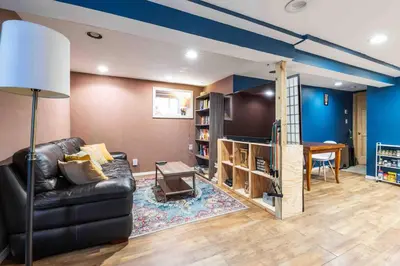 a living room with a black leather couch and a table at The Hygge Way, 20MIN TO NYC Times Sq in North Bergen