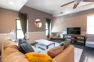 a living room with a couch and a flat screen tv at 1918 Duplex with Character City Center in Philadelphia
