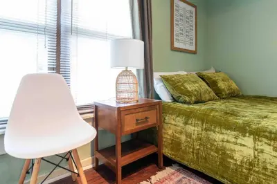 a bedroom with a bed and a chair and a lamp at 1918 Duplex with Character City Center in Philadelphia
