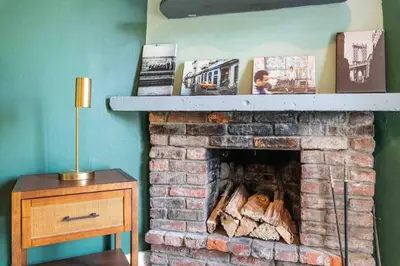 a living room with a brick fireplace with a shelf at 1918 Duplex with Character City Center in Philadelphia