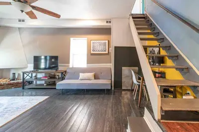 a living room with a couch and a staircase at 1918 Duplex with Character City Center in Philadelphia