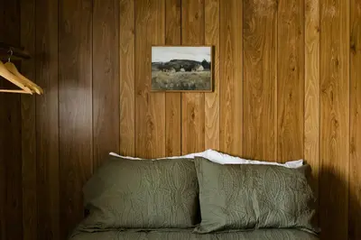 a bedroom with a bed with a picture on the wall at Beaver Creek Cabin 1 in Strasburg