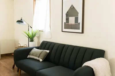 a black couch in a living room with a pillow at Beaver Creek Cabin 1 in Strasburg