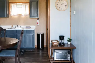 a kitchen with a table and a clock on the wall at Beaver Creek Cabin 5 in Strasburg