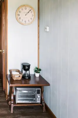 a microwave on a table with a clock on the wall at Beaver Creek Cabin 5 in Strasburg