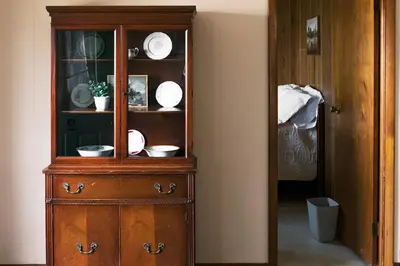 a wooden cabinet with dishes on it in a room at Beaver Creek Cabin 2 in Strasburg