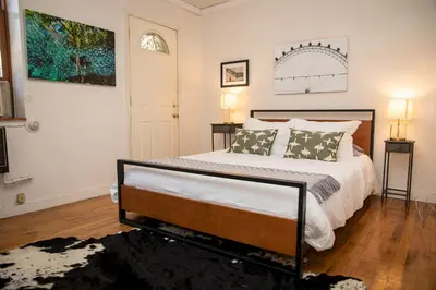 a bedroom with a large bed and two lamps at Sunny Fully Furnished Studio in Chelsea in New York