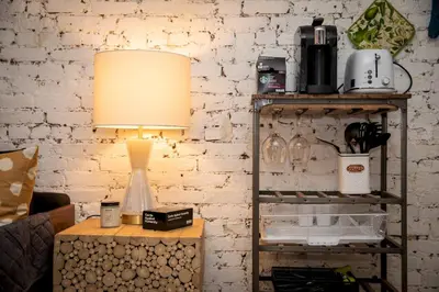a lamp on a table next to a brick wall at Sunny Fully Furnished Studio in Chelsea in New York