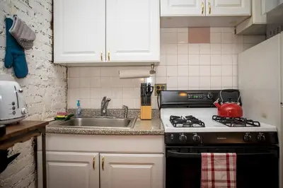 a kitchen with a stove and a sink at Sunny Fully Furnished Studio in Chelsea in New York