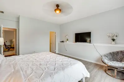 a white bedroom with a bed and a chair at 5 Mi to Rutgers University New Jersey Guest Suite in South River