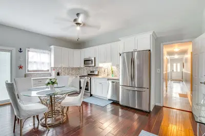 a kitchen with a table and a stainless steel refrigerator at 5 Mi to Rutgers University New Jersey Guest Suite in South River