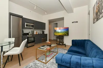 a living room with a blue couch and a table at The Wolf of Wall Street Apartment in New York