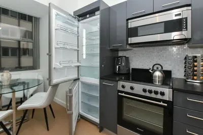 a kitchen with stainless steel appliances and a glass table at The Wolf of Wall Street Apartment in New York