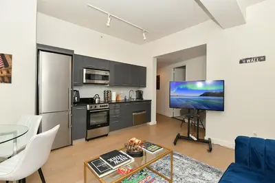 a living room with a blue couch and a tv at The Wolf of Wall Street Apartment in New York