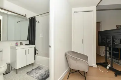 a bathroom with a chair and a television in it at The Wolf of Wall Street Apartment in New York