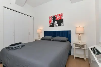a bedroom with a bed with a blue head board at The Wolf of Wall Street Apartment in New York