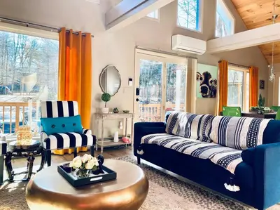 a living room with a blue couch and a table at Villa MiaNova A Modern Hideout in the Woods in Lake Ariel