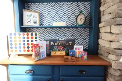 a blue dresser with books and a clock on a wall at Villa MiaNova A Modern Hideout in the Woods in Lake Ariel