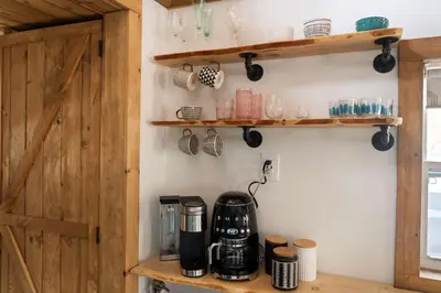 a kitchen with wooden shelves and a coffee maker on a counter at Perfect Couples Cabin Fireplace Firepit & Wine Nearby in Hawley