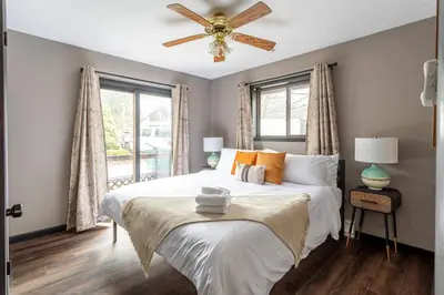 a bedroom with a bed and a ceiling fan at Water Front Dream Hot Tub Fire Pit King Bed in Tobyhanna