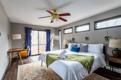 a bedroom with a large bed with a ceiling fan at Water Front Dream Hot Tub Fire Pit King Bed in Tobyhanna